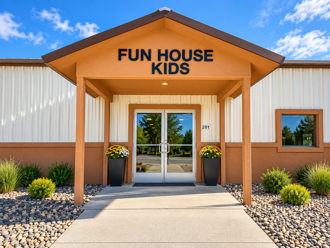 Fun House Kids entrance with glass doors and flower planters on a sunny day.