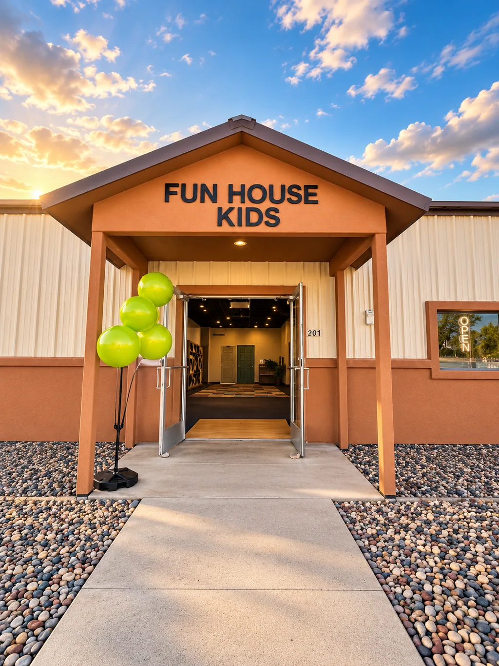 Fun House Kids entrance with green balloons at sunset.